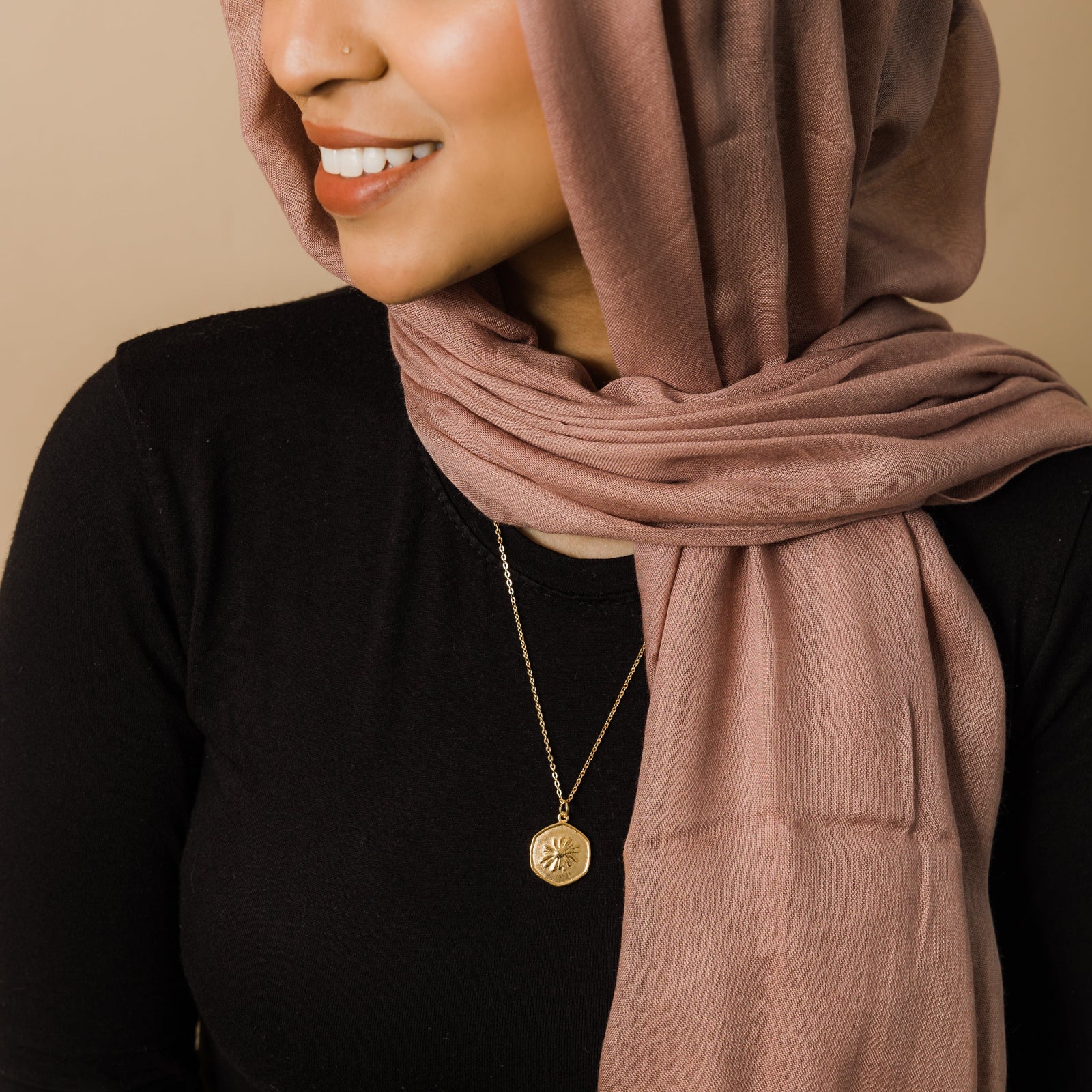 Close up of the gold April | Birth Flower Pendant as worn by the model.