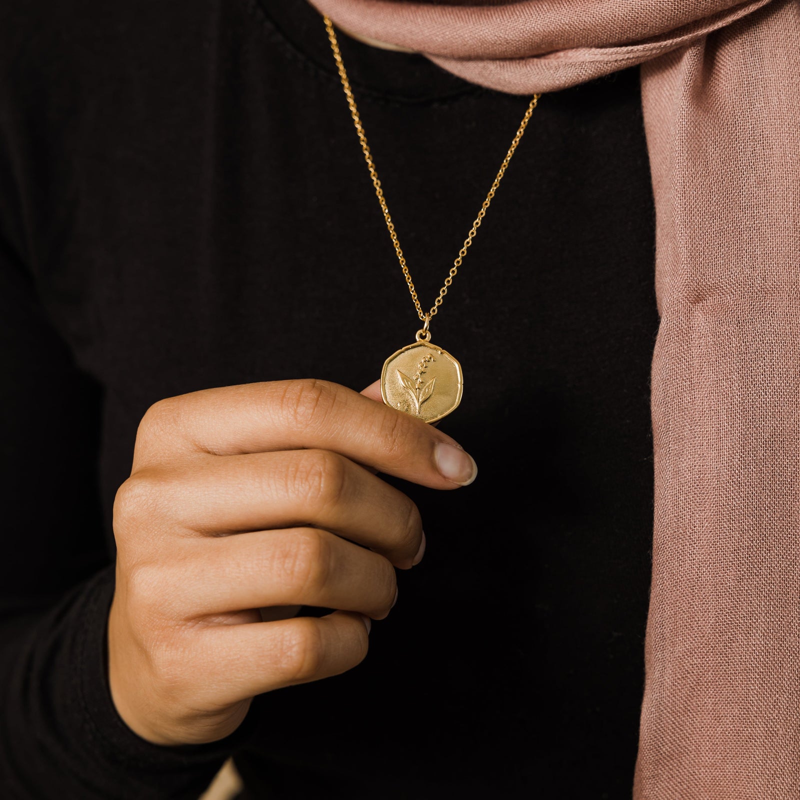 Close up of the gold May | Birth Flower Pendant as worn by the model.