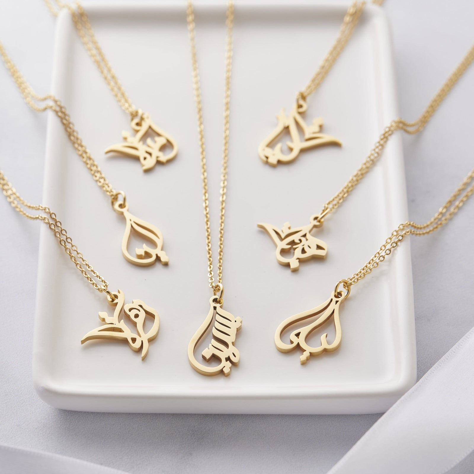 Photo of the gold Ready Calligraphy Name Necklace in 7 different variants.