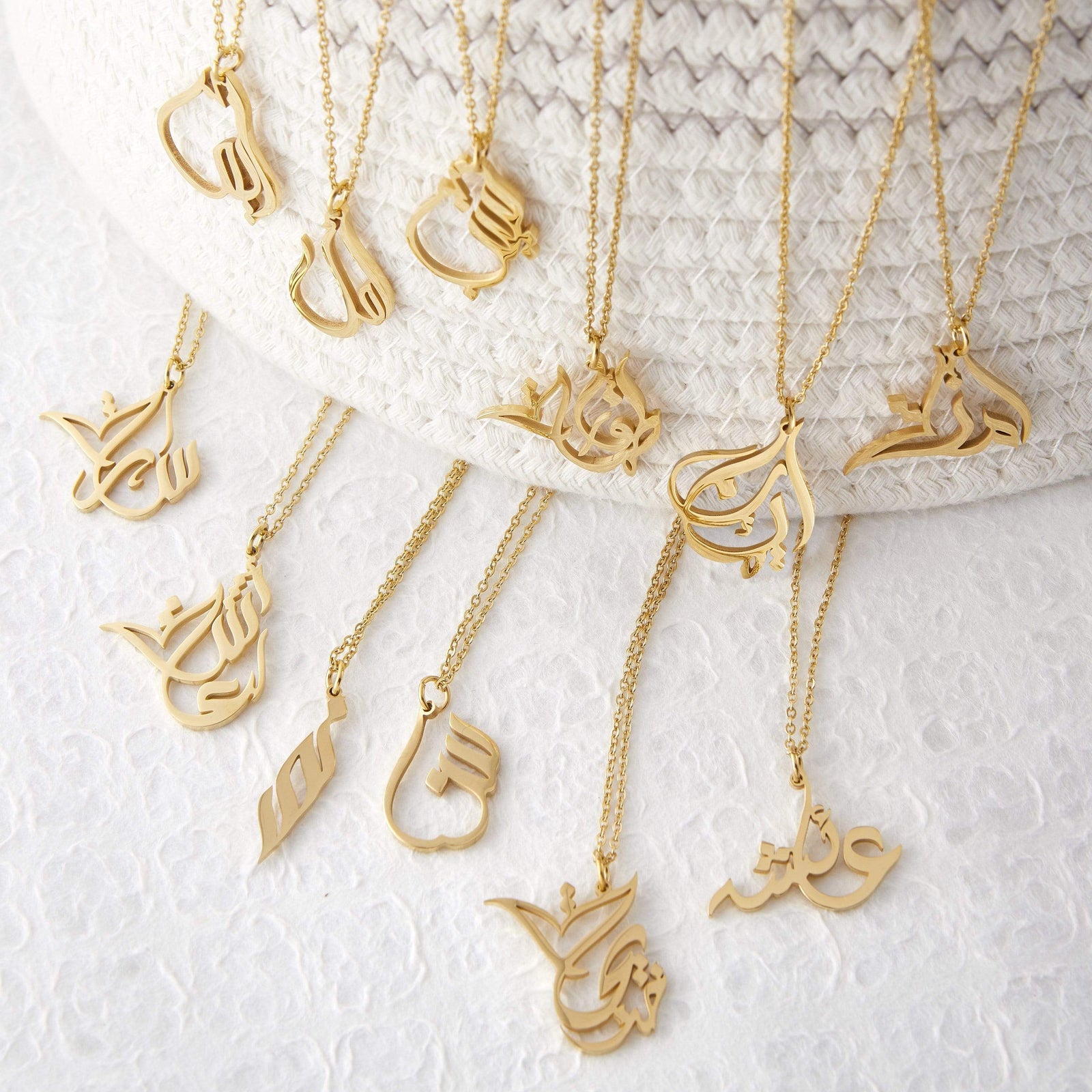 Photo of the gold Ready Calligraphy Name Necklace in 12 different variants.