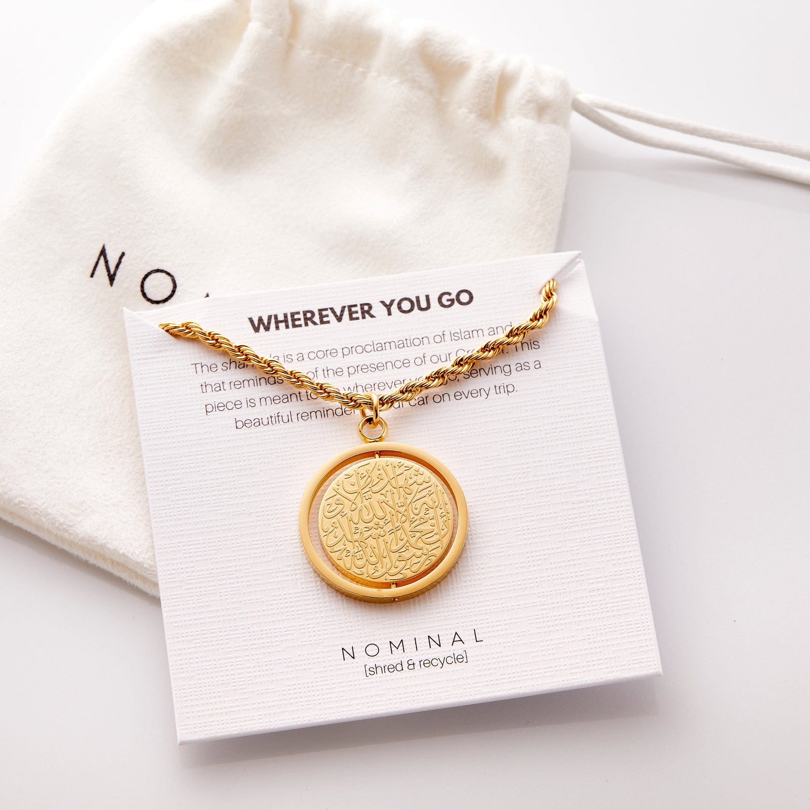 Gold Shahada car hanger displayed on a Nominal card reading “Wherever You Go” with pouch in the background.