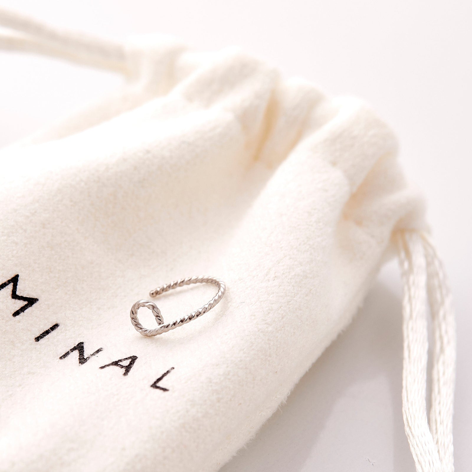 The silverTwirl Nose Hoop resting on the nominal pouch