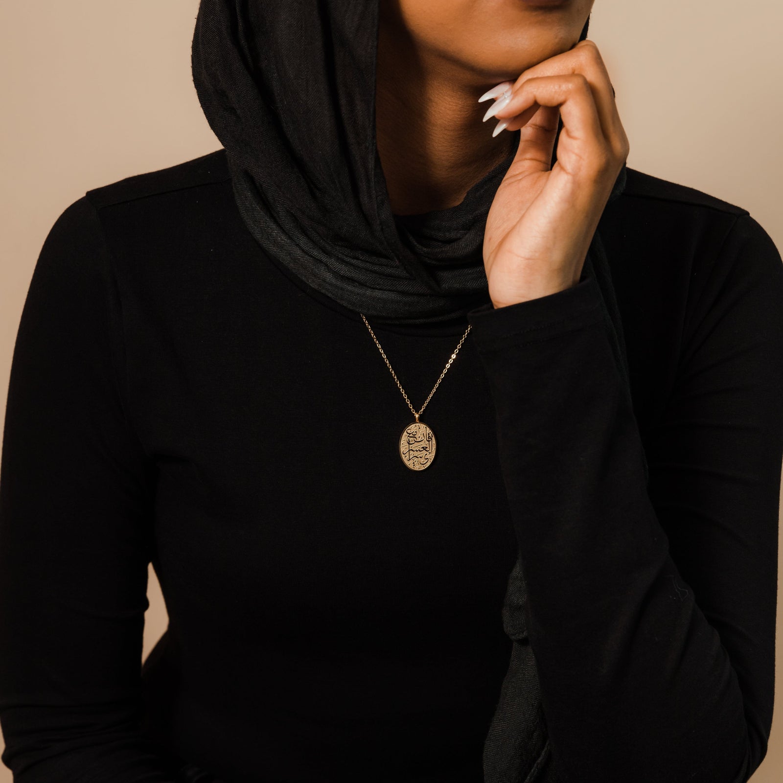Photo of the model wearing the gold "Verily, with Hardship Comes Ease" Oval Necklace.