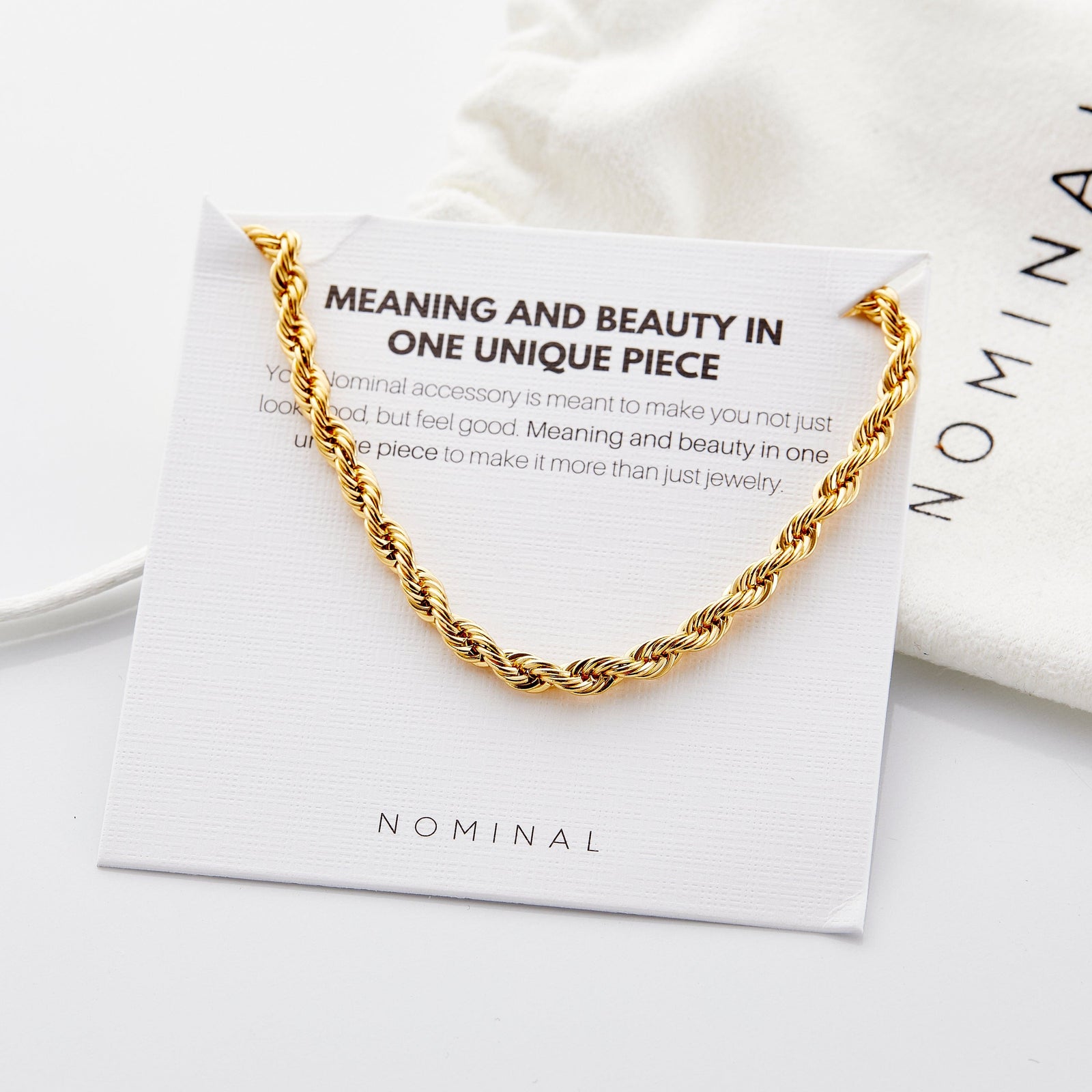Gold rope chain anklet displayed on a branded Nominal card with text about meaning and beauty.