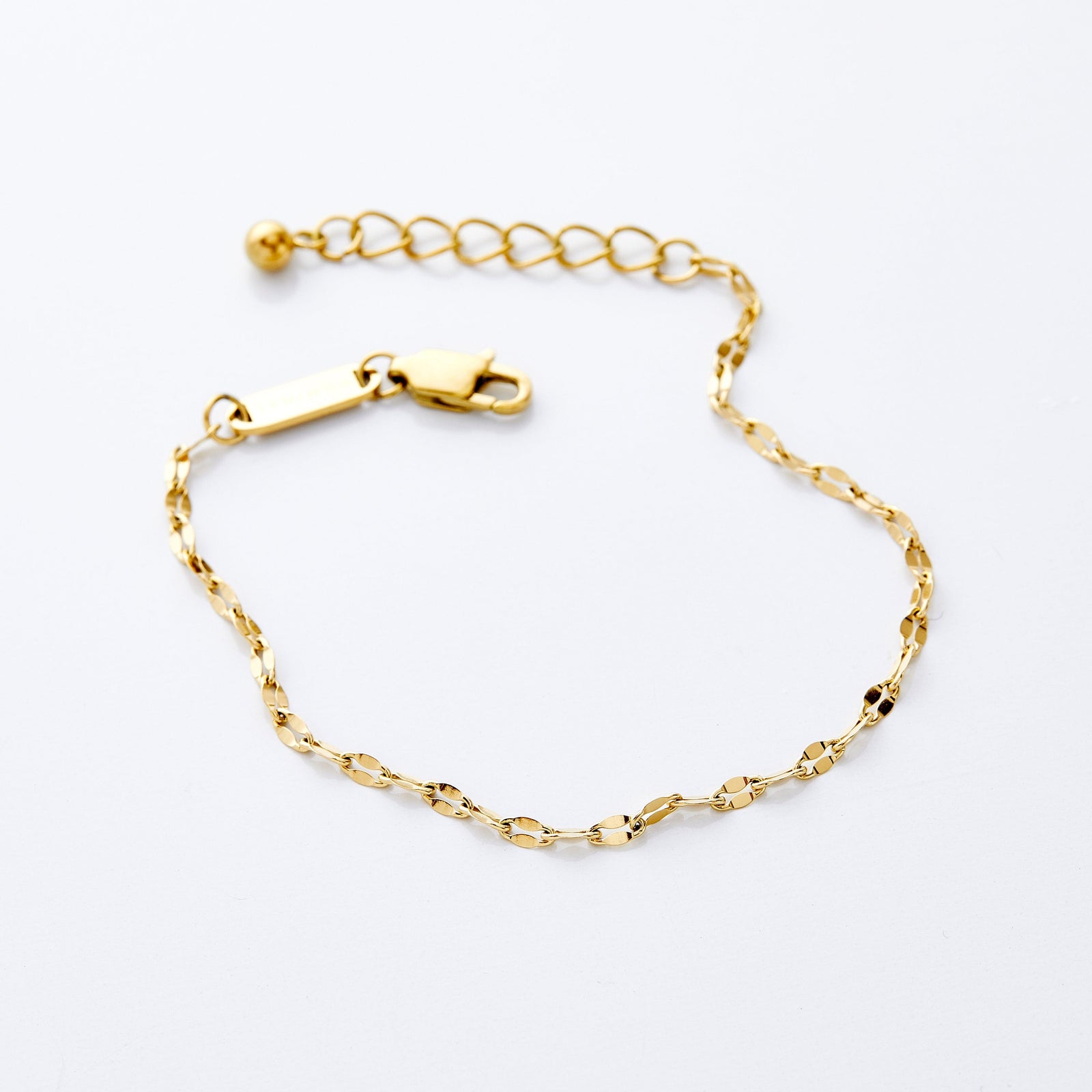 Gold flutter chain bracelet with adjustable extender, displayed on a white background.