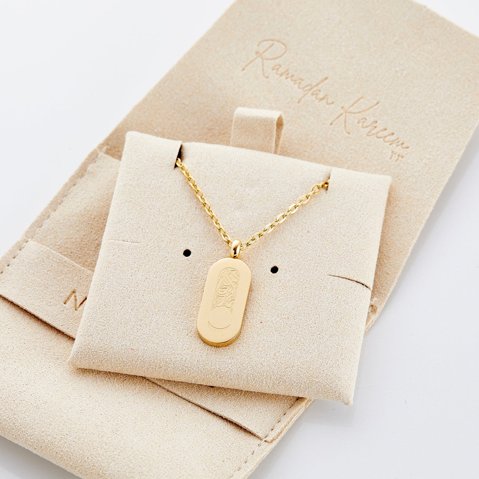 Close up of the gold Alhamdulillah Moon Necklace on its packaging.