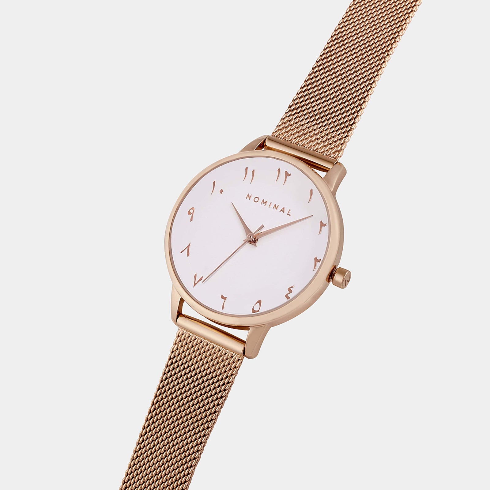 Close-up of the rose gold mesh strap watch with minimalist Arabic numerals, displayed against a neutral background