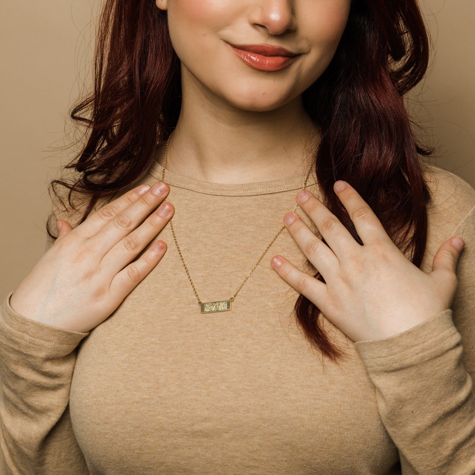 Close up of the gold Shahada Bar Necklace as worn by the model.